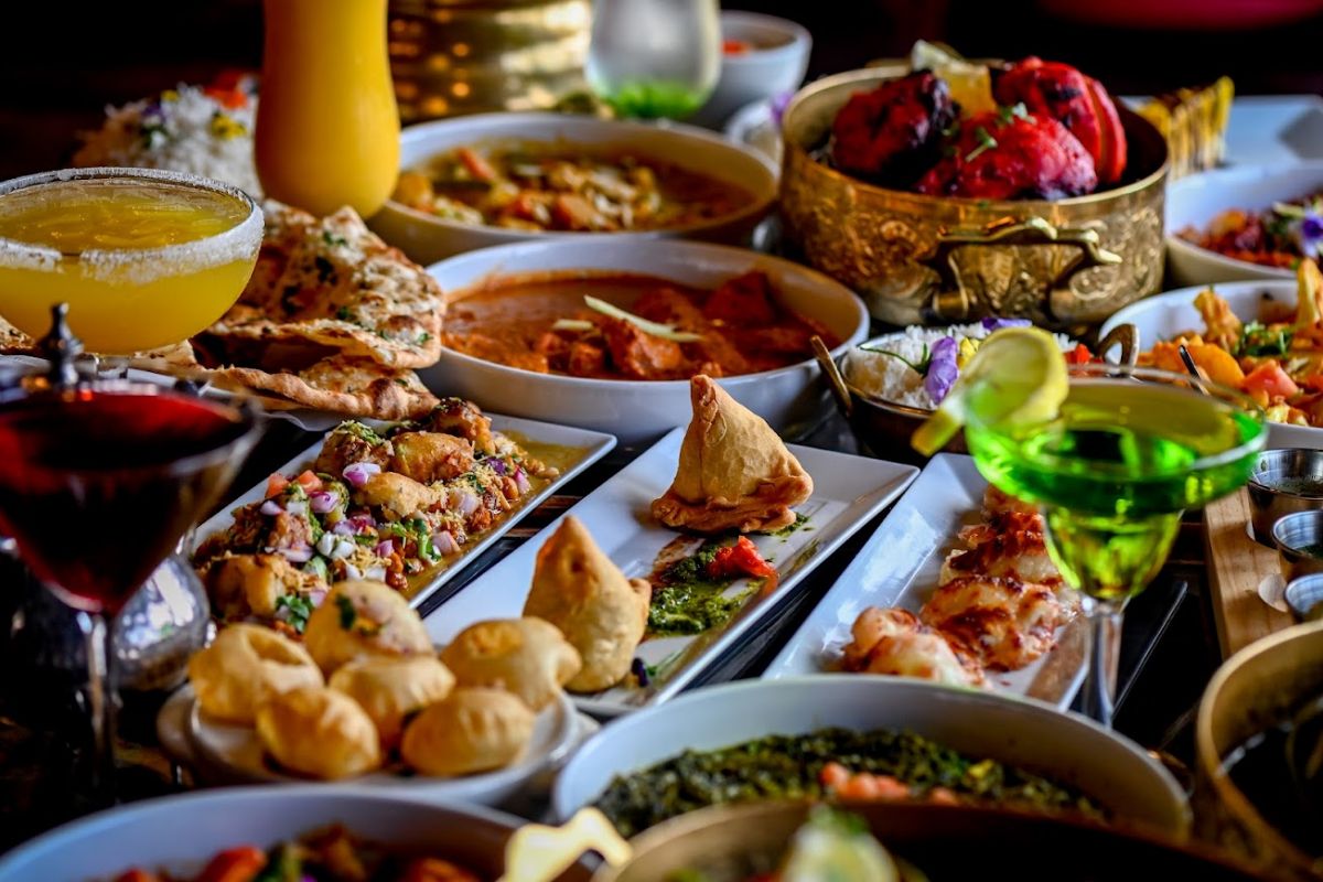 Party platter of curries, tandoori, samosas and chaat with cocktails
