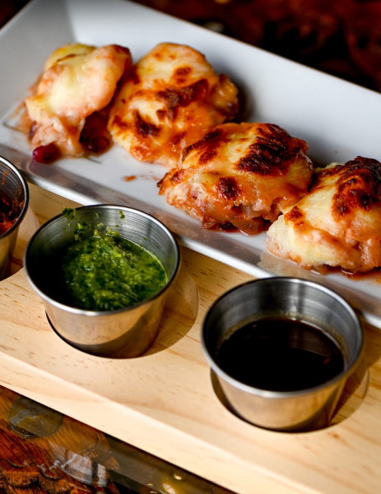 Cheese-topped naan bites with mint and tamarind chutneys