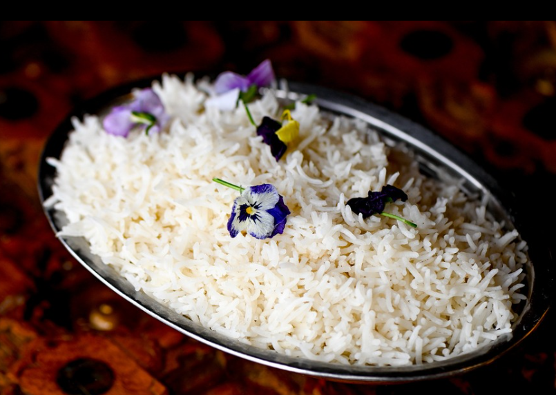 Fluffy basmati rice garnished with edible pansy flowers